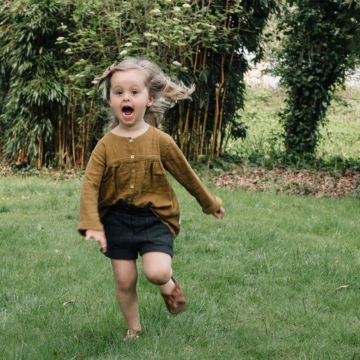 Une fillette qui court avec son short en gaze de coton