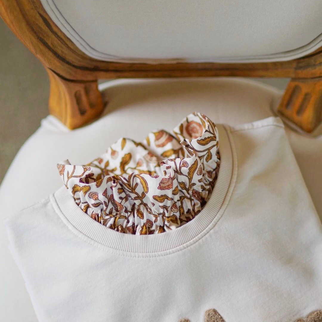 Col amovible en coton d'inspiration blockprint glissé sous un sweat écru