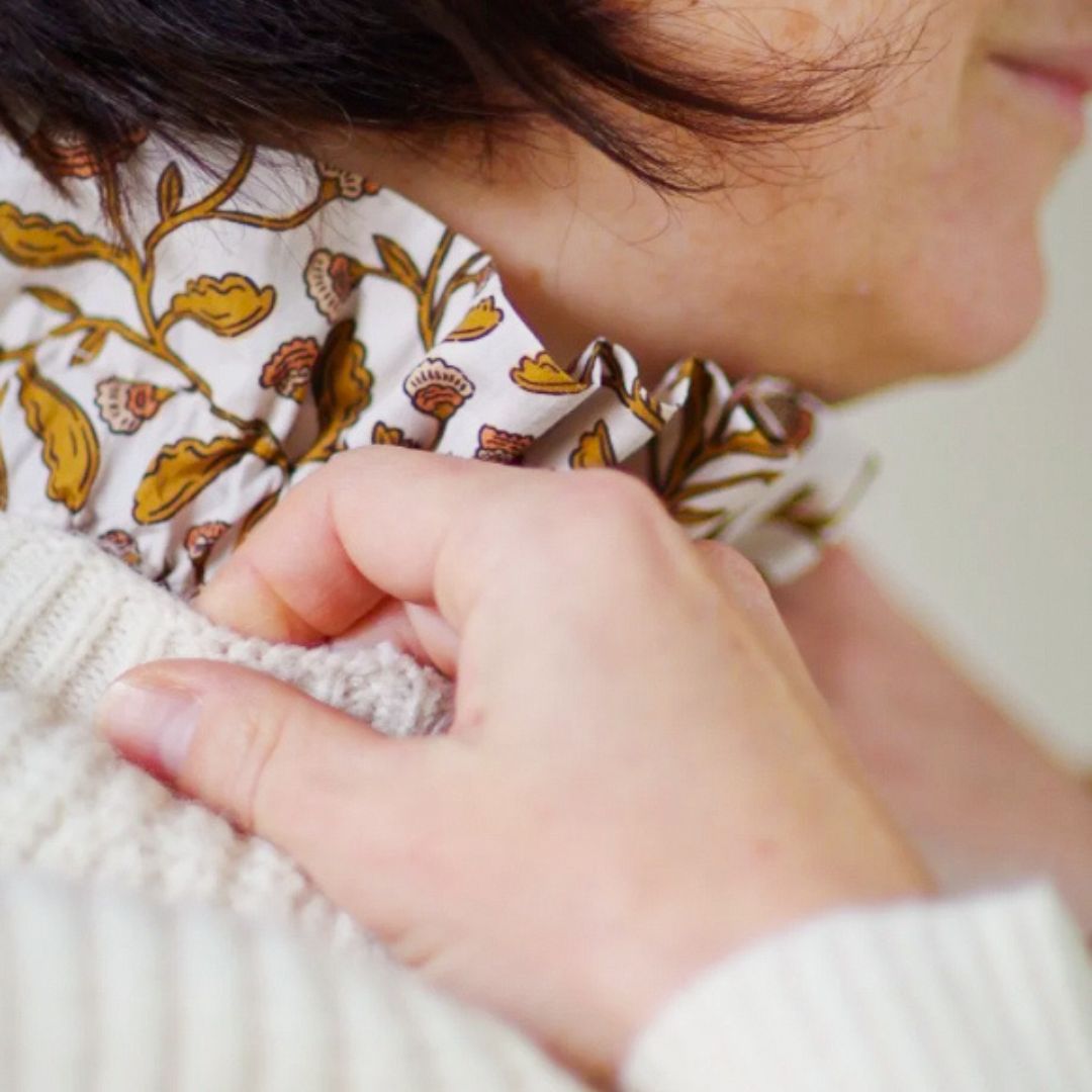 Col amovible à l'imprimé d'inspirateur blockprint glissé sous un pull écru et porté par une femme